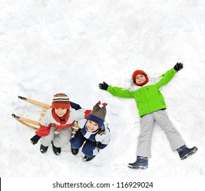 Happy Kids With Sledding On Snow Ground