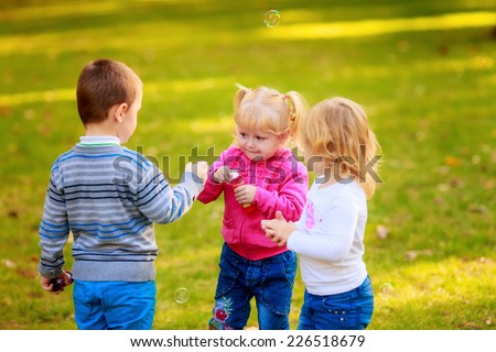 Similar – children playing in the sand, having a conversation over sand toys