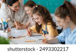 Happy kids and teacher at school. Woman and children are working in the class.