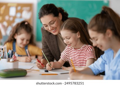 Happy kids and teacher at school. Woman and children are working in the class. - Powered by Shutterstock