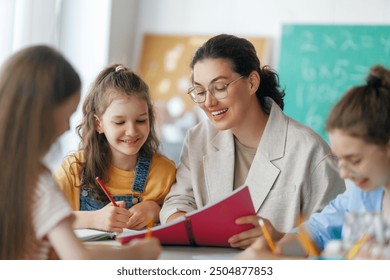 Happy kids and teacher at school. Woman and children are working in the class. - Powered by Shutterstock