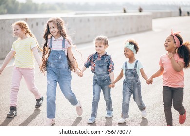 Happy Kids Walking Holding Hands. The Concept Of Unity, Friendship And Intercultural Communication