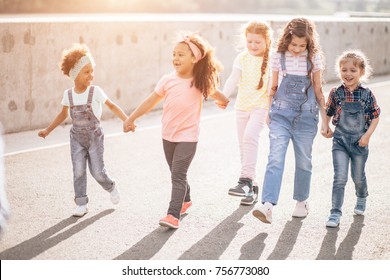 Happy Kids Walking Holding Hands. The Concept Of Unity, Friendship And Intercultural Communication