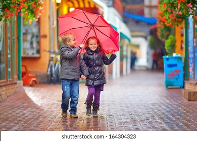 happy kids walking under the rain on colorful street - Powered by Shutterstock