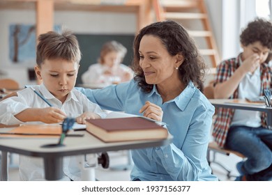 Happy Kind Teacher Is Helping Kids In Elementary School Lessons