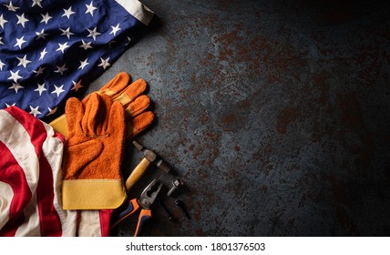 Happy Labor day concept. American flag with different construction tools on dark stone background, with copy space for text. - Shutterstock ID 1801376503