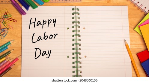 Happy Labor Day Text Over Open Book Against Multiple School Equipment On Wooden Table. Labor Day Celebration Concept