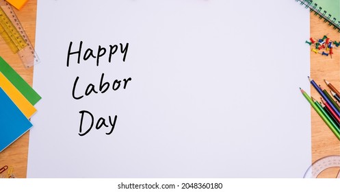 Happy Labor Day Text Over White Paper Against Multiple School Equipment On Wooden Table. Labor Day Celebration Concept