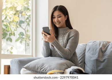 Happy lady relax at home alone sit on couch in comfortable pose share good news at social media via cellphone smiling enjoy weekend order goods food online in phone app - Shutterstock ID 2297970041