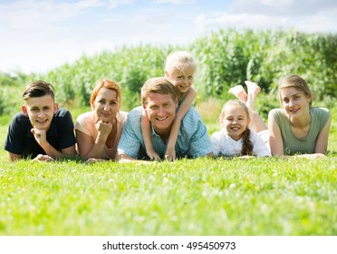 happy large family with four different age children lying on the grass in park on summer day - Shutterstock ID 495450973