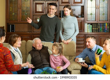 Happy Large Family Gathered In Parental Home For Family Party, Talking In Cozy Living Room. High Quality Photo