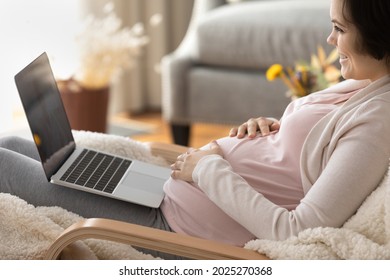 Happy Late Pregnant Girl Using Laptop, Using Virtual Telemedicine App For Consulting Doctor Online. Expecting Mom Resting In Armchair, Making Video Call, Looking At Screen, Smiling, Laughing