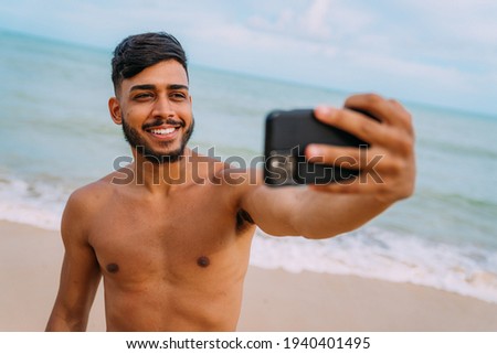 Happy latin american man making selfie beach background , sunny summer colors.