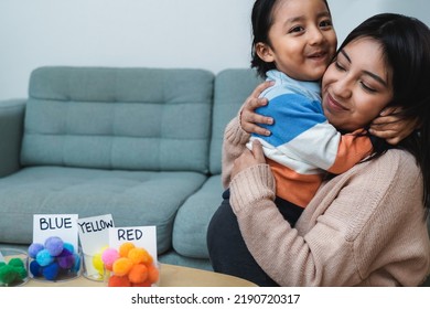 Happy Latin American Mother And Son Hugging Each While Playing Together At Home - Family Love Concept - Focus On Mom Face