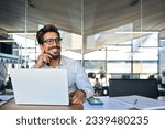Happy Latin business man working at laptop in office looking away. Happy young businessman professional using computer sitting at desk thinking of corporate technology ai solutions. Copy space