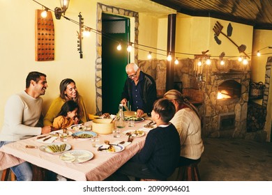 Happy latin family cooking together during dinner time at home - Soft focus on grandfather face - Powered by Shutterstock