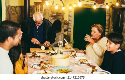 Happy Latin Family Cooking Together During Dinner Time At Home - Soft Focus On Grandfather Face