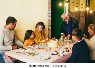 Happy Latin Family Cooking Together During Dinner Time At Home - Focus On Grandfather Face