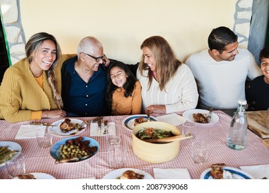 Happy latin family having fun eating together at vintage restaurant - Focus on female kid face