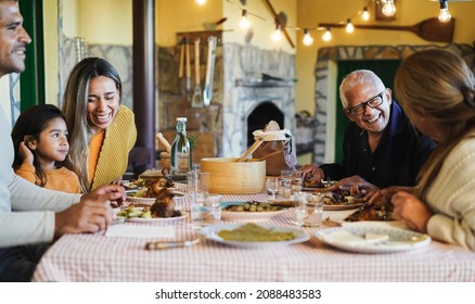 Happy latin family having fun eating together at home - Focus on grandfather face