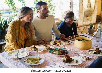 Happy Latin Family Having Fun Eating Together During Home Dinner - Focus On Mother Face