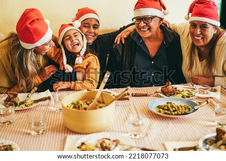 Happy latin family having fun eating together during Christmas time - Soft focus on girl face