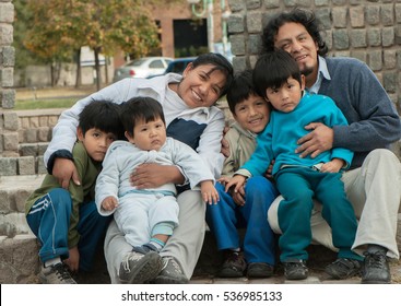 Happy Latin Family Sitting In The Street