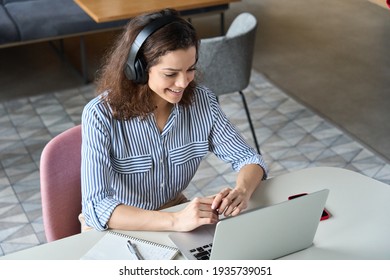 Happy Latin Girl College Student Wearing Headphones Watching Distance Online Learning Class, Remote University Webinar Or Having Talk On Laptop Video Call Virtual Meeting Seminar At Home Or Campus.