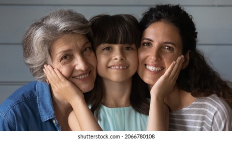 Happy Latin Girl, Young Mom, Elder Grandma Posing Together, Looking At Camera, Smiling, Hugging With Face Cheek Touches, Love, Care, Support, Gratitude. Three Family Generations Head Shot Portrait