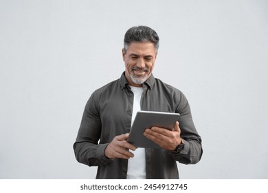 Happy Latin Hispanic bearded stylish mature adult professional business man, smiling Indian senior businessman CEO holding digital tablet using tab application standing on isolated white background - Powered by Shutterstock