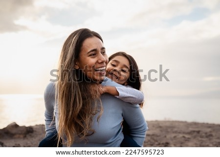 Happy Latin mother enjoying time with her child on the beach - Family and love concept