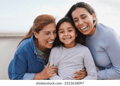 Happy latin multi generational family having tender moment together outdoor - Female child smiling on camera  - Powered by Shutterstock