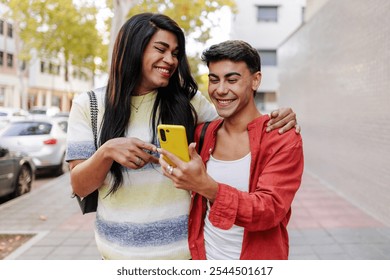 Happy latin transgender woman and man using smartphone on street - Powered by Shutterstock