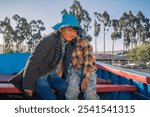 happy latino children hugging each other on a boat ride on a lake titicaca in bolivia - concept of happiness