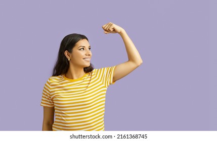 Happy Latino Girl Isolated On Purple Studio Background Show Power Gesture. Smiling Young Ethnic Woman Demonstrate Strength And Leadership. You Can Do It, Powerful Female.