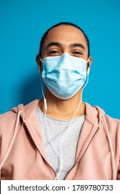 Happy Latino Man With Medical Mask And Headphones At Home. Coronavirus Concept.