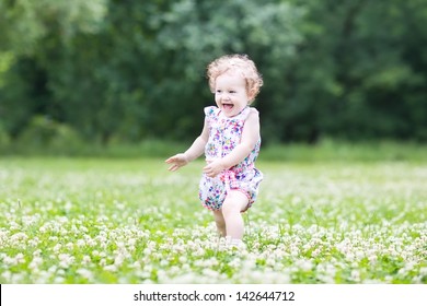 Happy Laughing Baby Girl Running In A Clover Field