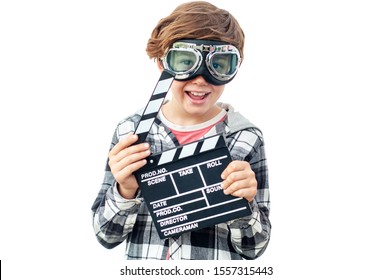 Happy Laughing Boy With Pilot Glasses Holding Clapper Board. Happy Teenager Racer Wants To Be A Movie Star. Cinema Concept With Clapperboard. Isolated