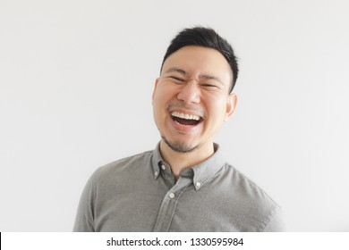 Happy And Laughing Face Of Ordinary Asian Man In Grey Shirt. Concept Of Charming Laugh.