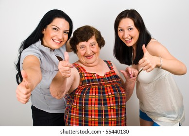 Happy laughing grandma with her granddaughter standing in a row and giving thumbs up - Powered by Shutterstock