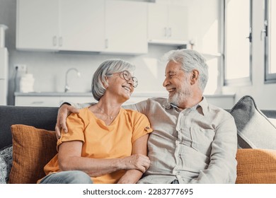 Happy laughing older married couple talking, laughing, standing in home interior together, hugging with love, enjoying close relationships, trust, support, care, feeling joy, tenderness - Powered by Shutterstock