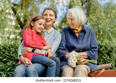 happy laughing people of different generations in the park on a bench. Joyful meetings of family members - Powered by Shutterstock