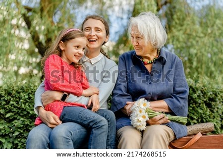 happy laughing people of different generations in the park on a bench. Joyful meetings of family members