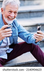 A Happy Laughing Senior Man Is Sitting On The Stairs Outdoors And Flirting On The Phone.