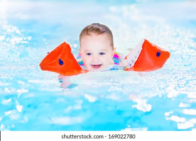 Happy Laughing Toddler Girl Having Fun In A Swimming Pool