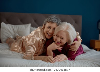 Happy laughing two elderly women enjoying time together during pajama party - Powered by Shutterstock