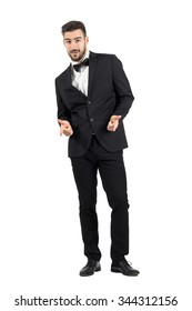 Happy Laughing Young Luxurious Man In Tuxedo Pointing At Camera. Full Body Length Portrait Isolated Over White Studio Background.