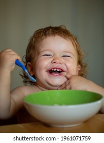 Happy Launching Baby Eating Himself With A Spoon. Lick Tasty Fingers.