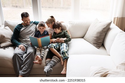 Happy, learning and parents reading a book with children for bonding, fun and quality time. Knowledge, information and boys excited about a story on the lounge sofa with their mother and father - Powered by Shutterstock