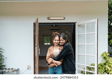Happy Lesbian Couple Embracing in Front of New Home - LGBT Moving Day Concept - Powered by Shutterstock